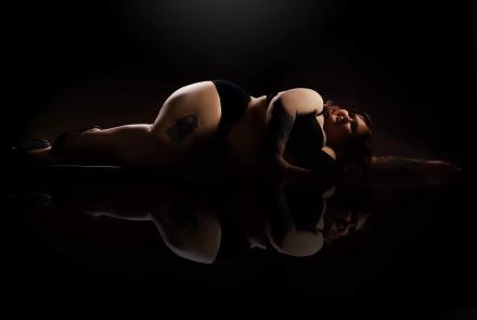 UK cam girl Athena Witch lays on a reflective floor on a photoshoot