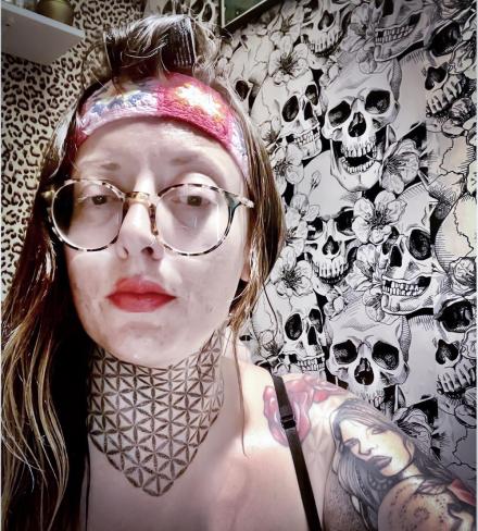 Cam model Aubrey Sky takes a selfie wearing a headband and glasses