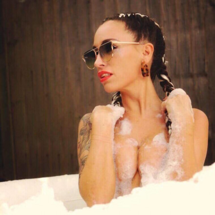 Brooklyn B in a bath in sun glasses with her arms up covering her breasts