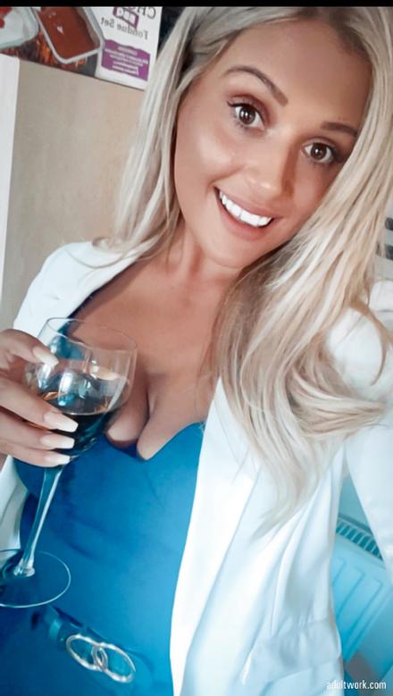 Live cam model Lacey Harding posing in white coat, holding a glass of wine