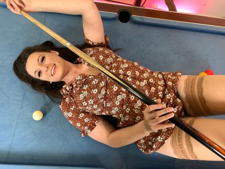 Ivy Rain lying on top of a pool table